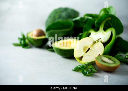 Frullato di verde in un barattolo di vetro con un fresco e verde biologico di frutta e verdura su sfondo grigio. Dieta di primavera, sano materie vegetariano vegano, concetto, detox colazione, pulizia alcalina mangiare. Spazio di copia Foto Stock