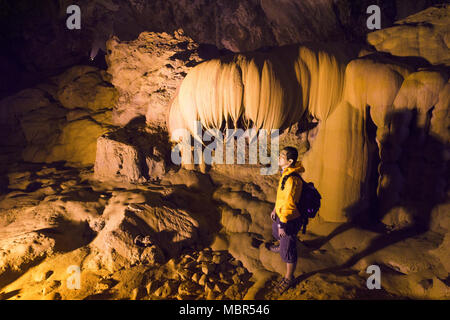 L'uomo esplorare la splendida grotta presso Nguom ngao grotta nei pressi di Ban Gioc cascate , Cao Bang - Nord del Vietnam. Foto Stock