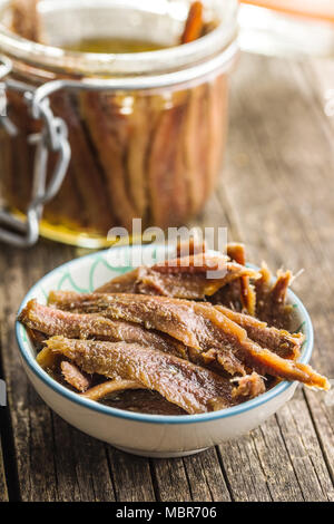 Filetti di Acciuga in olio su tavola di legno. Foto Stock