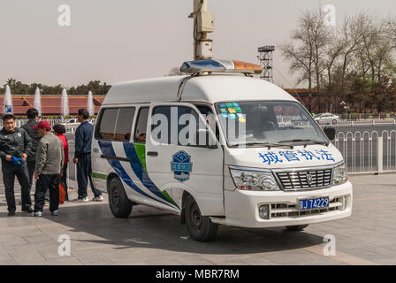 Pechino, Cina - 27 Aprile 2010: Bianco e blu polizia van parcheggiato sul lato della piazza Tiananmen. Ufficiali all'interno e all'esterno. Foto Stock