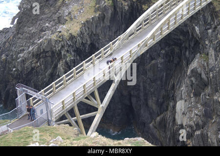 Turisti e fotografi attraversando il Mizen Head gorge sulla passerella pedonale che porta alla vecchia stazione di segnale e il faro e la punta di s/w Irlanda Foto Stock