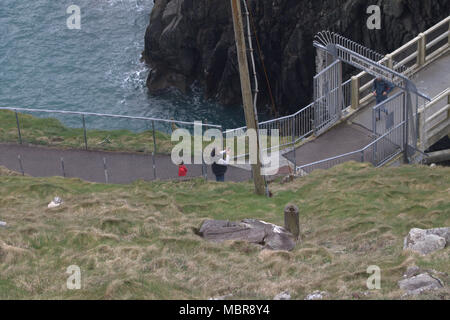 Turisti e fotografi attraversando il Mizen Head gorge sulla passerella pedonale che porta alla vecchia stazione di segnale e il faro e la punta di s/w Irlanda Foto Stock