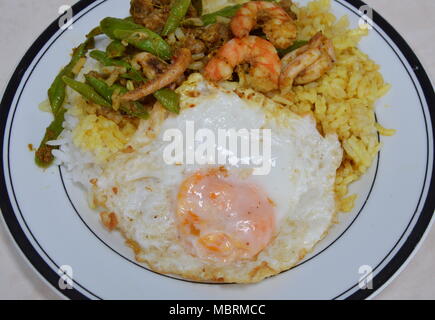 Spicy stir-pesce fritto con curry topping uovo fritto sul riso Foto Stock