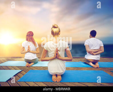 Gruppo di persone a praticare lo yoga all'aperto Foto Stock