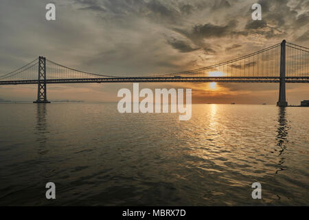 Il sorgere del sole sopra il San Francisco-Oakland Bay Bridge. Foto Stock