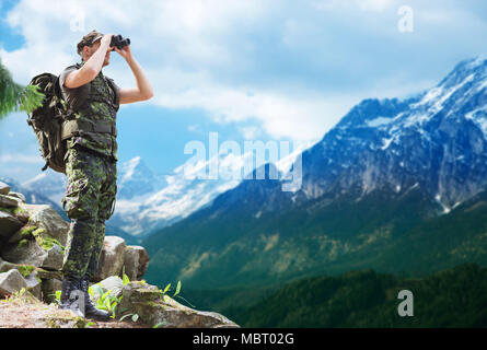 Soldato con zaino cercando di binocolo Foto Stock