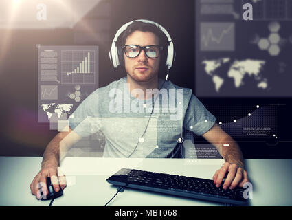Uomo in cuffia con computer su schermi virtuali Foto Stock