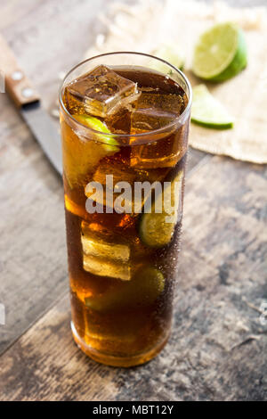 Cuba libre. Cocktail con rum, calce e di ghiaccio sul tavolo di legno Foto Stock