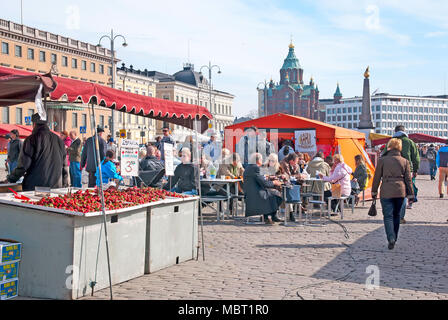 HELSINKI, Finlandia - 16 Aprile 2011: persone all'aria aperta caffè sulla piazza del mercato vicino al Golfo di Finlandia. Sullo sfondo è la Cattedrale Uspenski Foto Stock