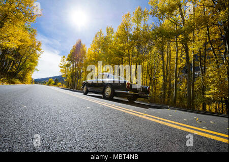 Un 1961 Lancia Flaminia unità auto attraverso il Rock Creek Canyon circondato da Autunno a colori nella Sierra orientale nei pressi di Toms Place, California. Foto Stock