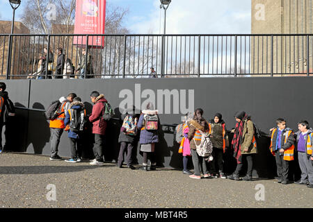 Gruppo di bambini delle scuole primarie britanniche che visitano la coda della galleria d'arte Tate Modern a Bankside nel sud di Londra, Inghilterra Regno Unito KATHY DEWITT Foto Stock