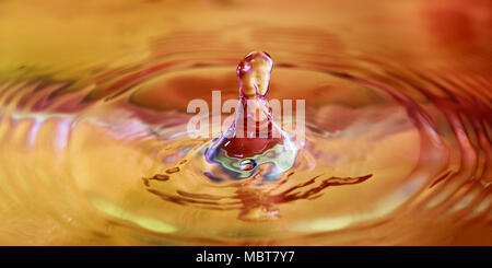 Colorato goccia d'acqua splash in acqua macrofotografia Foto Stock
