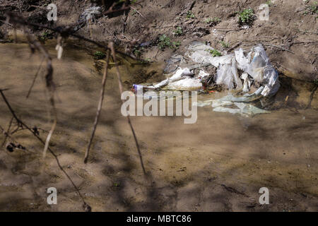 Pesante di acqua inquinata con flusso di rifiuti domestici Foto Stock