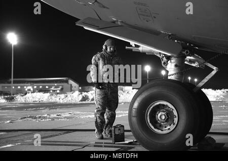 Senior Airman Garrett battaglia, 736th Manutenzione aeromobili squadrone di comunicazione e navigazione artigiano, sorge vicino al naso di un C-17A Globemaster III come il velivolo viene rifornito di combustibile, 5 gennaio 2018, alla Dover Air Force Base, Del. battaglia e altri 736th AMXS manutentori preparato il velivolo per una missione a temperature in basso gli adolescenti con un vento gelido oscillando attorno a meno tre gradi. (U.S. Air Force Foto di Roland Balik) Foto Stock