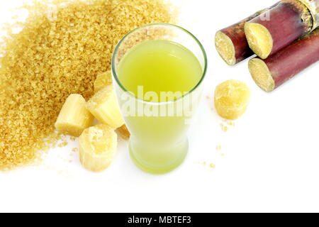 La canna da zucchero e succo di frutta fresco tagliato di canna da zucchero, di canna da zucchero granulato giallo marrone su sfondo bianco Foto Stock