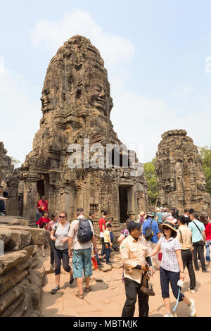 Tempio Bayon Cambogia - i turisti guardando i volti scolpiti di Buddha, tempio Bayon, Angkor Thom, sito patrimonio mondiale dell'UNESCO, Cambogia, Asia Foto Stock