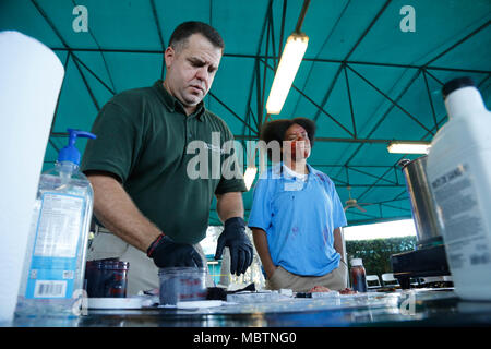 Rohm Kern un trucco artisti dal sud della Florida, crea ferisce simulato da un volontario in una formazione congiunta esercitare all'Homestead-Miami Speedway in Miami, Fla. gen. 11, 2018. Questo JTE focalizzata sulla creazione di capacità di risposta e la perfetta la transizione tra il primo locale i soccorritori e il follow-sul supporto fornito da La Guardia Nazionale e Active duty soldati. (Brevetto statunitense n. S. esercito da Foto. Andrea Salgado Rivera) Foto Stock