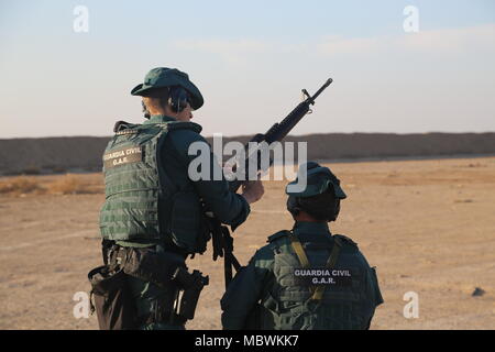 Una Guardia Civil spagnola membro della coalizione assiste ad un soldato iracheno la M4 fucile durante un live esercitazione antincendio presso il Camp Besmaya,, 7 gennaio 2018. Questa formazione fa parte del complesso di Combined Joint Task Force - Funzionamento inerenti risolvere la costruzione di capacità del partner di missione che si concentra sulla formazione e rafforzare la capacità di partnership forze che lottano ISIS. CJTF-funzione OIR è la coalizione globale per sconfiggere ISIS in Iraq e la Siria. (U.S. Esercito foto di Spc. Shannon Westpfahl) Foto Stock