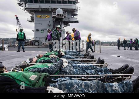 La USS John C. Stennis (CVN 74) è una portaerei a propulsione nucleare della classe Nimitz della United States Navy, commissionata nel 1995. Il 10 gennaio 2018, i membri dell'equipaggio praticarono il movimento delle vittime durante un'esercitazione antincendio e per le vittime di massa mentre la nave era nel porto di Bremerton, Washington. L'immagine d'archivio documenta le attività coordinate di addestramento alle emergenze nella cabina di pilotaggio del vettore. Foto Stock