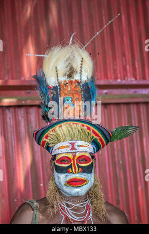 Ritratto di un uomo adulto con face painting e piume tradizionale copricapo, Mount Hagen spettacolo culturale, Papua Nuova Guinea Foto Stock