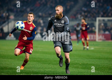 Bronx, New York, Stati Uniti d'America. 11 Aprile, 2018. Jo Inge Berget (9) di NYCFC insegue giù una sfera contro Brooks Lennon (12) del Real Salt Lake durante la seconda metà del gioco. NYCFC ha vinto 4-0. Foto Stock