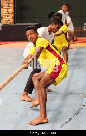 Il gioco tradizionale di Assam "Rosi Tona Khel" ( corda tirando), Guwahati, Assam, India. Il 12 aprile 2018. I giocatori in azione nel gioco tradizionale di Assam "Rosi Tona Khel" ( corda tirando) durante il XII APRILE 2018, Guwahati, Assam, India.indigeni Festival del Gioco. "Rosi Tona Khel" ( corda tirando) è uno sport che mette direttamente due squadre contro ogni e tirare le estremità opposte di una corda con l obiettivo di portare la corda in una certa distanza sulla forza della squadra avversaria pull del. Foto : David Talukdar. Foto Stock