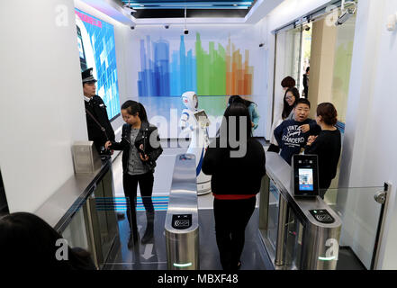 Shanghai, Cina. Xii Apr, 2018. Un cliente entra in un'area self service di Jiujiang Road ramo della China Construction Bank (CCB) a Shanghai in Cina orientale, Aprile 12, 2018. I clienti sono in grado di negoziare il 90 percento del denaro contante e non-cash business nel self-service area del ramo. Credito: Fang Zhe/Xinhua/Alamy Live News Foto Stock