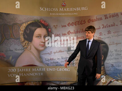 12 aprile 2018, Pattensen, Germania: Ernst August Junior di Hannover in piedi di fronte al '200 anni Marie e Goerg di Hannover" mostra banner presso il Castello di Marienburg. La mostra avrà inizio sabato 14 aprile, ed è dedicato alla Regina Maria il cui duecentesimo compleanno sarà in quel giorno. Foto: Holger Hollemann/dpa Foto Stock