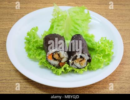 La cucina giapponese, Vagetarian tradizionale di riso giapponese maki sushi Roll roba con tofu e carote avvolte in Nori alghe servita sulla quercia verde. Foto Stock