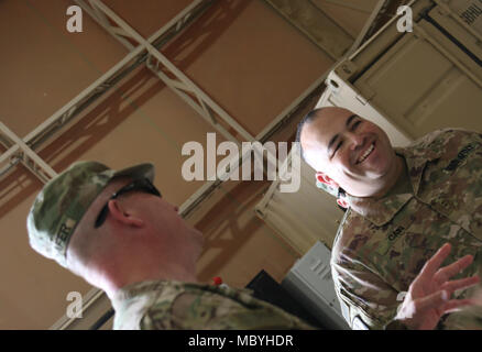 CAMP BUEHRING, Kuwait - Chief Warrant Officer 2 Allen Caino (a destra), un aereo e la difesa missilistica tecnico per Delta batteria, 1° Battaglione, sessantaduesima difesa aerea reggimento di artiglieria, xi difesa aerea della brigata di artiglieria, Task Force Spartan, introduce il suo team e discute il loro lavoro con il Mag. Gen. Andrew Schafer, comandante generale della 28a Divisione di Fanteria e la Task Force Spartan, durante la sua visita Marzo 26. Foto Stock