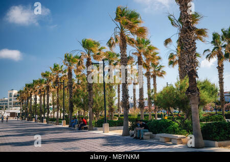 Valencia, Spagna - 2 Giugno 2017: percorso a piedi sulla giornata di sole sotto le palme. La spiaggia di Malvarrosa promenade a Valencia in Spagna. Foto Stock