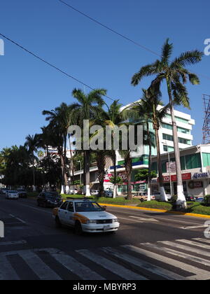 ACAPULCO, Messico Nord America su marzo 2018: edifici bianchi, attraversamento pedonale, vetture su strada panoramica con esotiche palme nella città messicana con Foto Stock