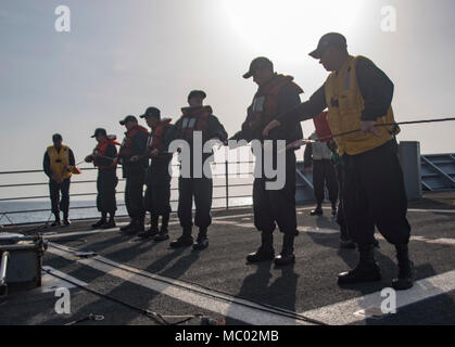 180105-N-DO281-1093 ARABIAN GLUF (GEN. 5, 2018) marinai uomo il telefono e la linea a distanza durante un rifornimento in mare, a bordo guidato-missili cruiser USS Monterey (CG 61). Il Monterey è distribuito negli Stati Uniti Quinta Flotta area di operazioni a sostegno della sicurezza marittima operazioni per rassicurare gli alleati e partner e preservare la libertà di navigazione e il libero flusso di commercio nella regione. (U.S. Foto di Marina di Massa Specialista comunicazione marinaio Trey Fowler) Foto Stock