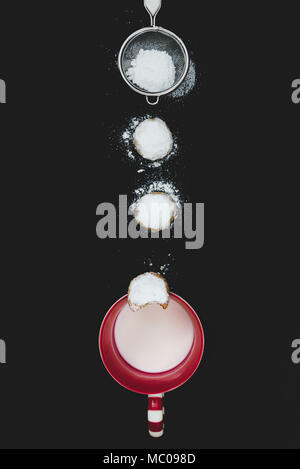 Biscotti ricoperti di una glassa di zucchero e un crivello inferiore e una tazza di latte di fo. Il Natale di cottura disposizione astratta. Foto Stock