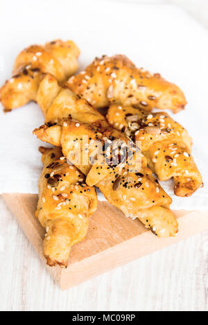 Vicino di casa cotto al forno mini croissant coperti con semi mix. La colazione del mattino. Foto Stock