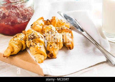 Vicino di casa cotto al forno mini croissant coperti con semi mix. La colazione del mattino. Foto Stock