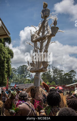 Orobe cantare cantare gruppo sfilando con un enorme quadro decorato con piume bianche, Mount Hagen spettacolo culturale, Papua Nuova Guinea Foto Stock