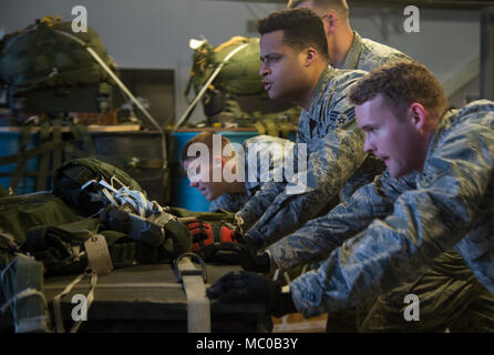 Stati Uniti Air Force aviatori assegnati alla 773d disponibilità logistica squadrone di combattimento volo mobilità spingere un 3.400-pound cargo pallet su un caricatore Halvorsen a base comune Elmendorf-Richardson, Alaska, Gennaio 18, 2018. La Halvorsen caricatore è un rapidamente dispiegabile, alta raggiungere meccanizzata del caricatore di aeromobili che possono trasportare e sollevare fino a 25.000 libbre di cargo e caricarlo su aerei militari e civili. JBER il combattimento la mobilità di volo è il più grande in PACAF, fornendo C-130 Hercules e C-17 Globemaster III unilaterali di airdrop airland e formazione per due ali e tre squadroni mentre a casa station Foto Stock