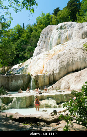 La popolazione locale godendo le sorgenti calde e travertino Piscine minerali alla Fossa Bianca, balena bianca, una cascata di origine vulcanica in Bagni San Gianna, Toscana Foto Stock