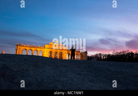 Gloriette in Schönbrunner Schloss Park a tarda sera in golden ore di luce. Bassa, ampio angolo di prospettiva, sparare a partire dal livello del suolo. Tourist rendendo un ph Foto Stock