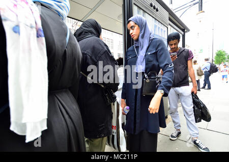 Londra, Inghilterra, Regno Unito. Le donne musulmane di indossare il velo islamico a una fermata d autobus Foto Stock