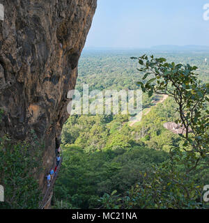 Vista sulla piazza di turisti salire la ripida scalinata di Sigiriya o Lions Rock in Sri Lanka. Foto Stock