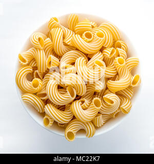 Rigati pasta in vaschetta bianca su sfondo bianco nel centro di close-up con parte superiore. Foto Stock