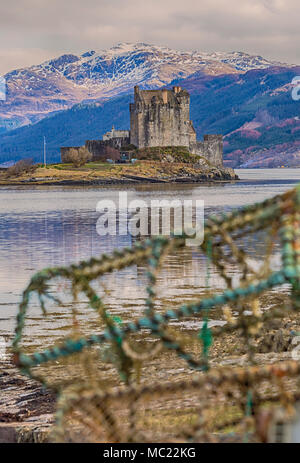 Eilean Donan Castle riflessa in Loch Long con aragosta pentole sul primo piano, Dornie, Highlands Occidentali, Scotland, Regno Unito in marzo - effetto hdr Foto Stock