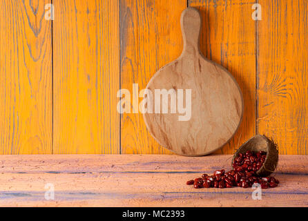 Tagliere in legno arancione sfondo viola Foto Stock