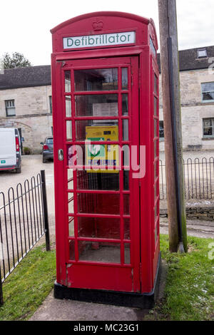 In disuso telefono rosso box ora convertiti alla stazione del defibrillatore per emergenza, Avening, Gloucestershire, Regno Unito Foto Stock