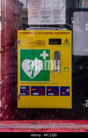 In disuso telefono rosso box ora convertiti alla stazione del defibrillatore per emergenza, Avening, Gloucestershire, Regno Unito Foto Stock