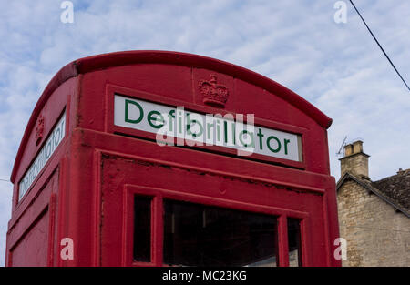 In disuso telefono rosso box ora convertiti alla stazione del defibrillatore per emergenza, Avening, Gloucestershire, Regno Unito Foto Stock