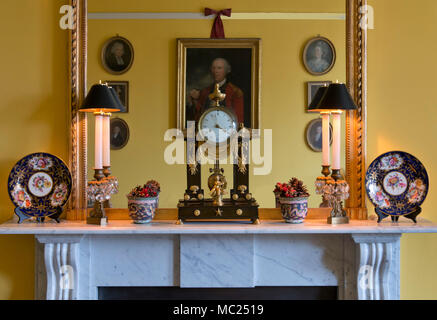 Un precoce tradizionale stile Vittoriano caminetto in marmo con Impero Francese pilastro orologio, candelabri, piastre di porcellana cinese, bicchieri di smalto ecc.. Foto Stock