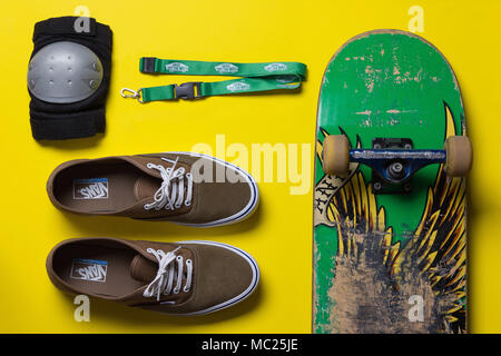 Lo skateboard e ingranaggio di pattino contro uno sfondo luminoso, vista dall'alto Foto Stock